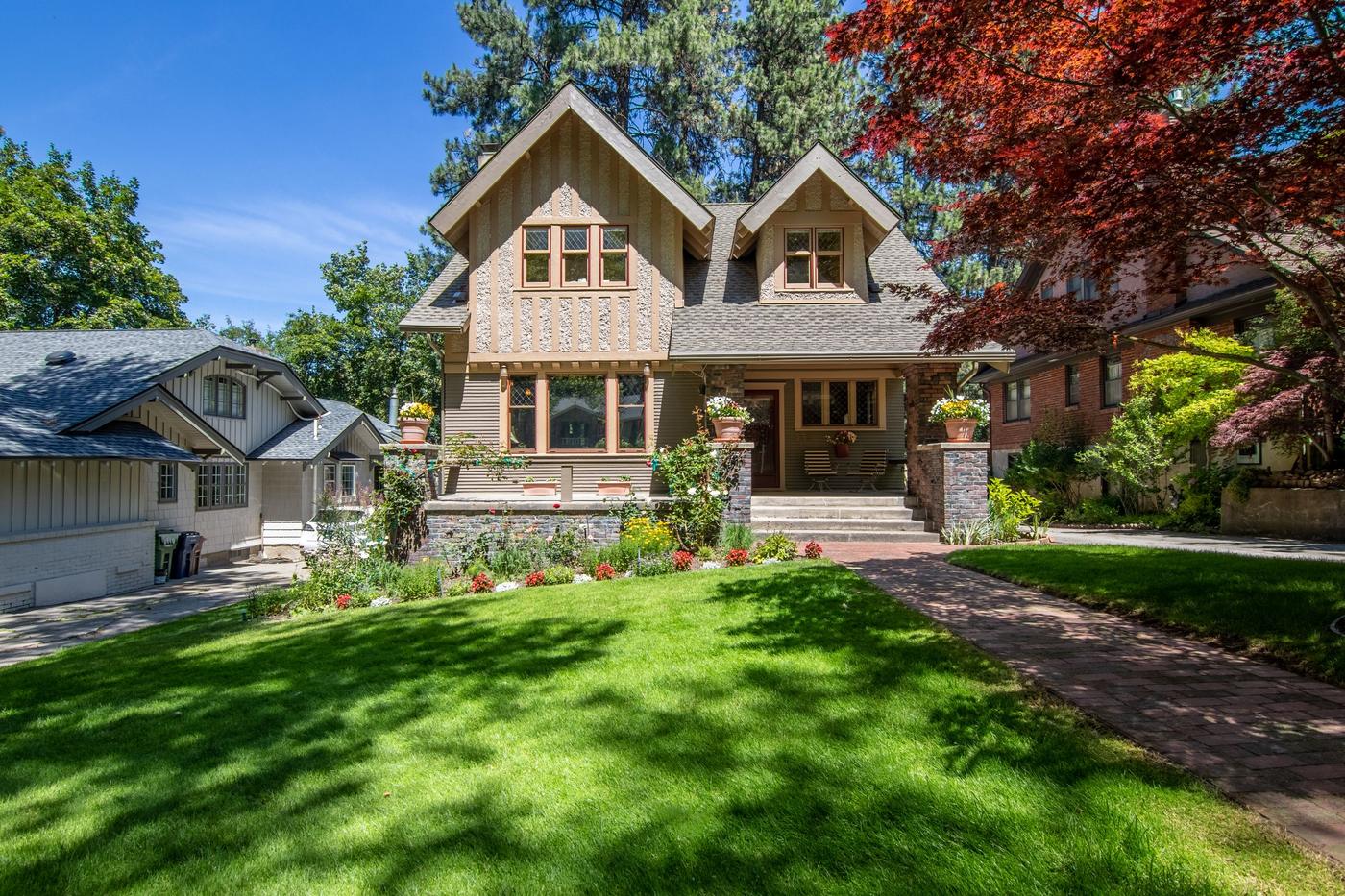 Craftsman bungalow with a wide lawn and brick walkway