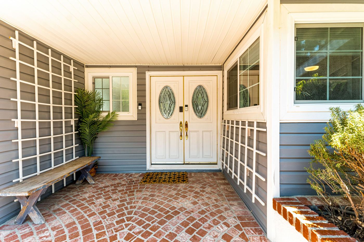 Covered front entry with white double doors